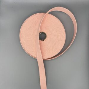 Soft pink grosgrain ribbon on grey background, perfect for wedding or event decorations, gift wrapping, and craft projects. High-quality, durable ribbon ideal for adding a stylish finishing touch.