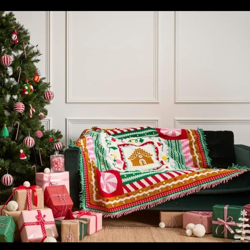 Christmas Christmas blanket featuring gingerbread house design, red, green, pink, and gold accents on present wrapping, festive decor, and holiday vibe with Christmas tree and gifts.