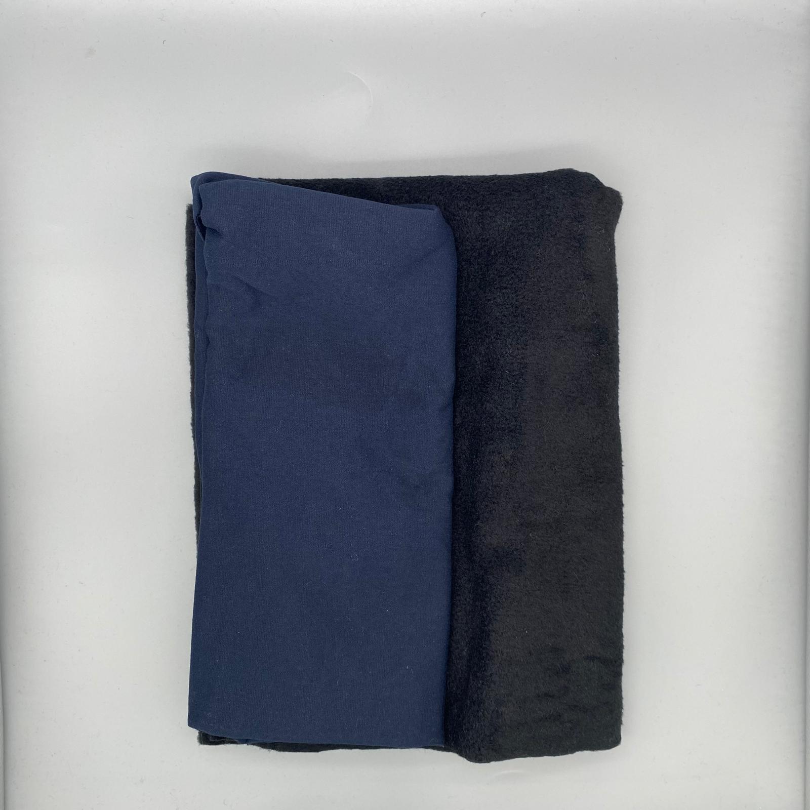 Soft deep blue and black fabrics neatly folded, suitable for bespoke clothing or upholstery projects from Fabric & Finery.