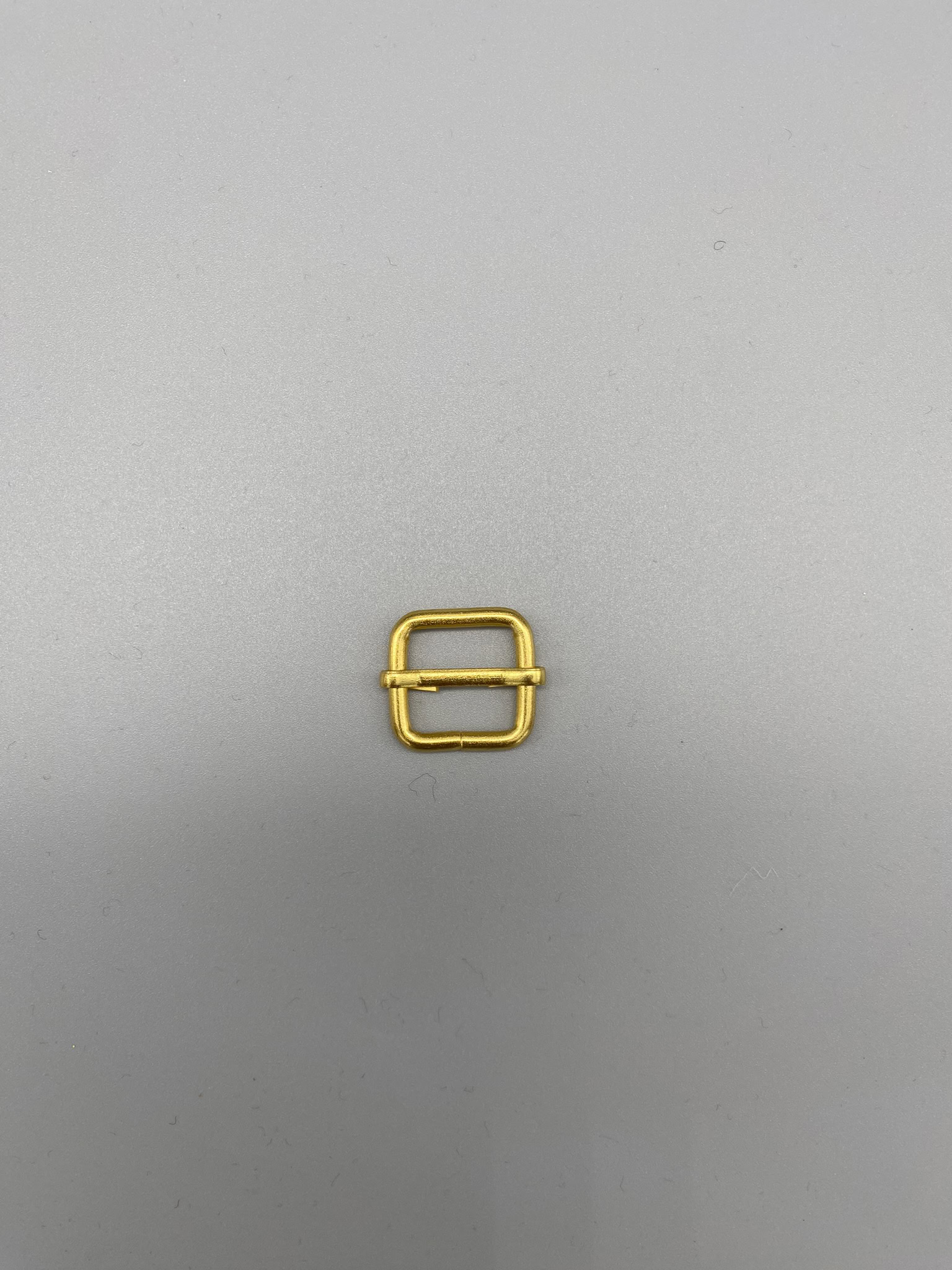 Gold fabric buckle for sewing and accessories, metal hardware for craft projects, sewing supplies, fabric fins, garment details, fashion accessories, and DIY craft components.