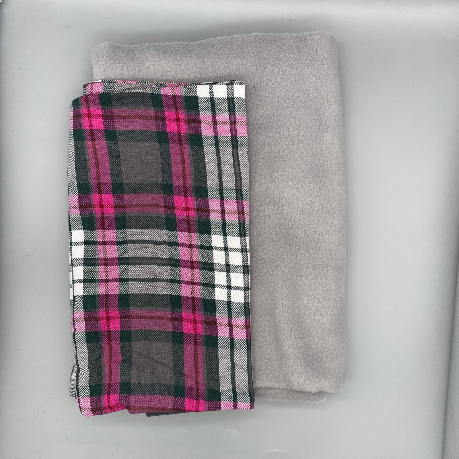 Soft grey fleece and vibrant pink and grey tartan fabric, perfect for cozy clothing, home decor, and craft projects. High-quality textiles from Fabric & Finery for stylish and comfortable designs.