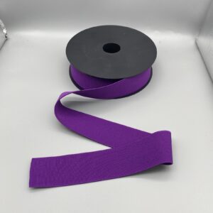 Purple grosgrain ribbon on black spool, ideal for sewing, crafting, and gift wrapping, available at Fabric & Finery UK.