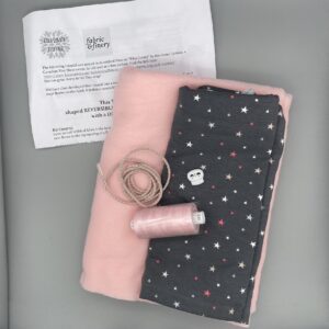 Soft pink fleece fabric, star printed jersey, pink embroidery thread, white plastic skull button, fabric sewing pattern, craft supplies for DIY garment making, fabric & finery stock, sewing and craft materials in the UK.