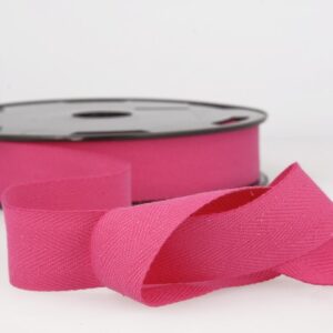 Pink grosgrain ribbon on spool for sewing and craft projects.