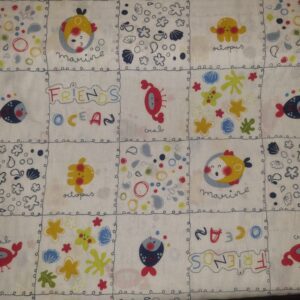 Bright, playful fabric featuring colourful ocean-themed illustrations such as octopuses, crabs, and marine life, ideal for children's clothing or nursery decor. Perfect for creative sewing projects.