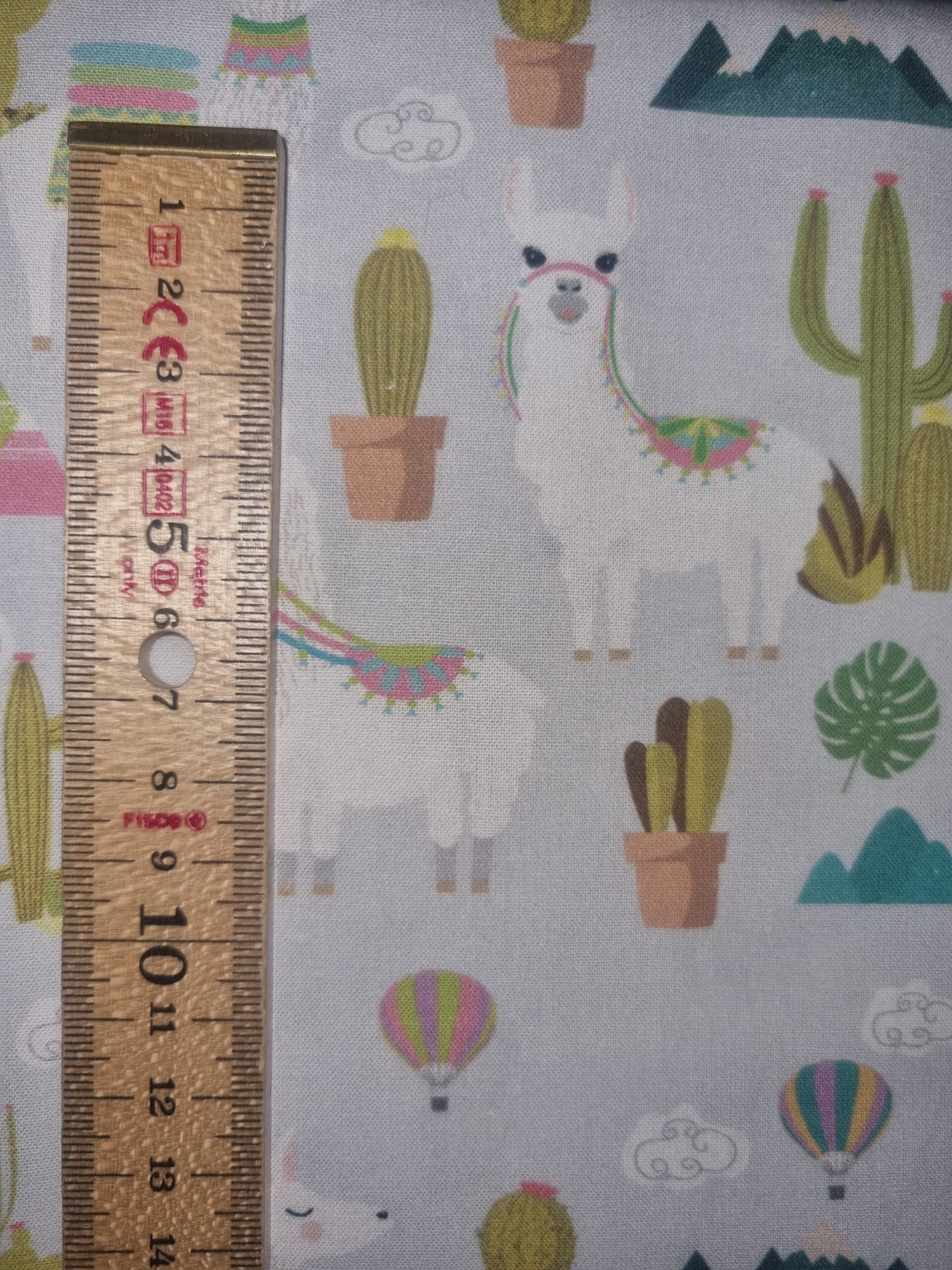 Colorful llama and desert-themed fabric with cacti and hot air balloons, perfect for whimsical and playful textile projects, children’s clothing, or craft decor. High-quality printed cotton fabric from Fabric & Finery UK.