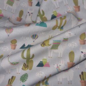 Vibrant llama and cactus printed fabric in pastel colours, perfect for trendy home decor, craft projects, and children's clothing, available at Fabric & Finery UK.