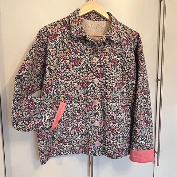 Vibrant floral patterned jacket with pink accents, ideal for stylish casualwear and spring fashion. Perfect for adding colour and elegance to your wardrobe.