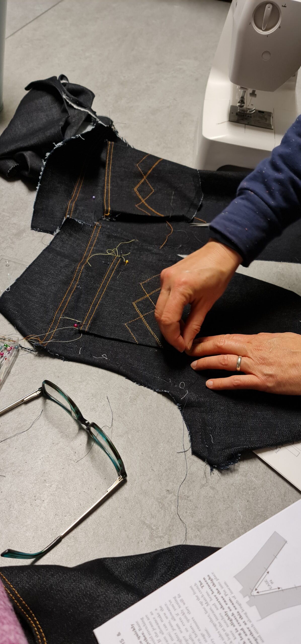 Damask upholstery fabric being sewn with orange thread for customised tailoring, on a sewing machine at Fabric & Finery, UK. Perfect for bespoke furniture upholstery and interior projects.