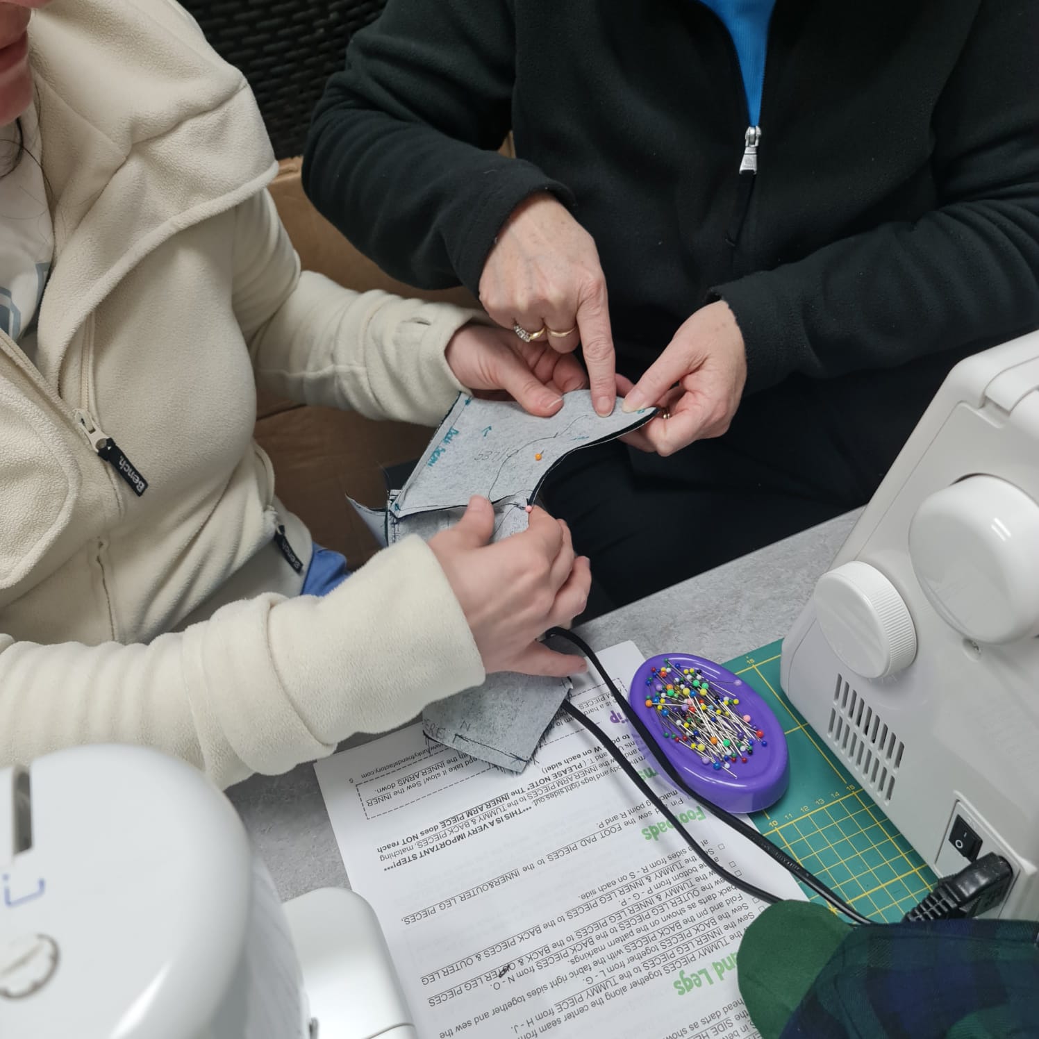 Fabric and finery sewing workshop with dressmakers working on pattern fitting and fabric construction. Creative textile design, sewing techniques, and fabric craftsmanship for bespoke garments.