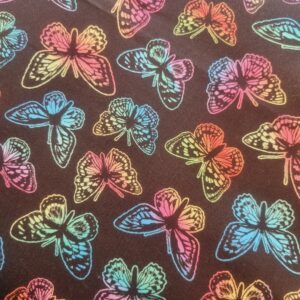 Vibrant rainbow butterfly print fabric, ideal for fashion, craft projects, and home decor, featuring colourful butterfly motifs on a dark background for a striking visual effect.