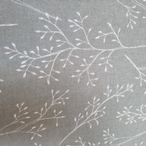 Delicate white embroidery on soft grey linen fabric showcasing a botanical leaf and branch pattern, perfect for sophisticated home textiles or elegant apparel designs.
