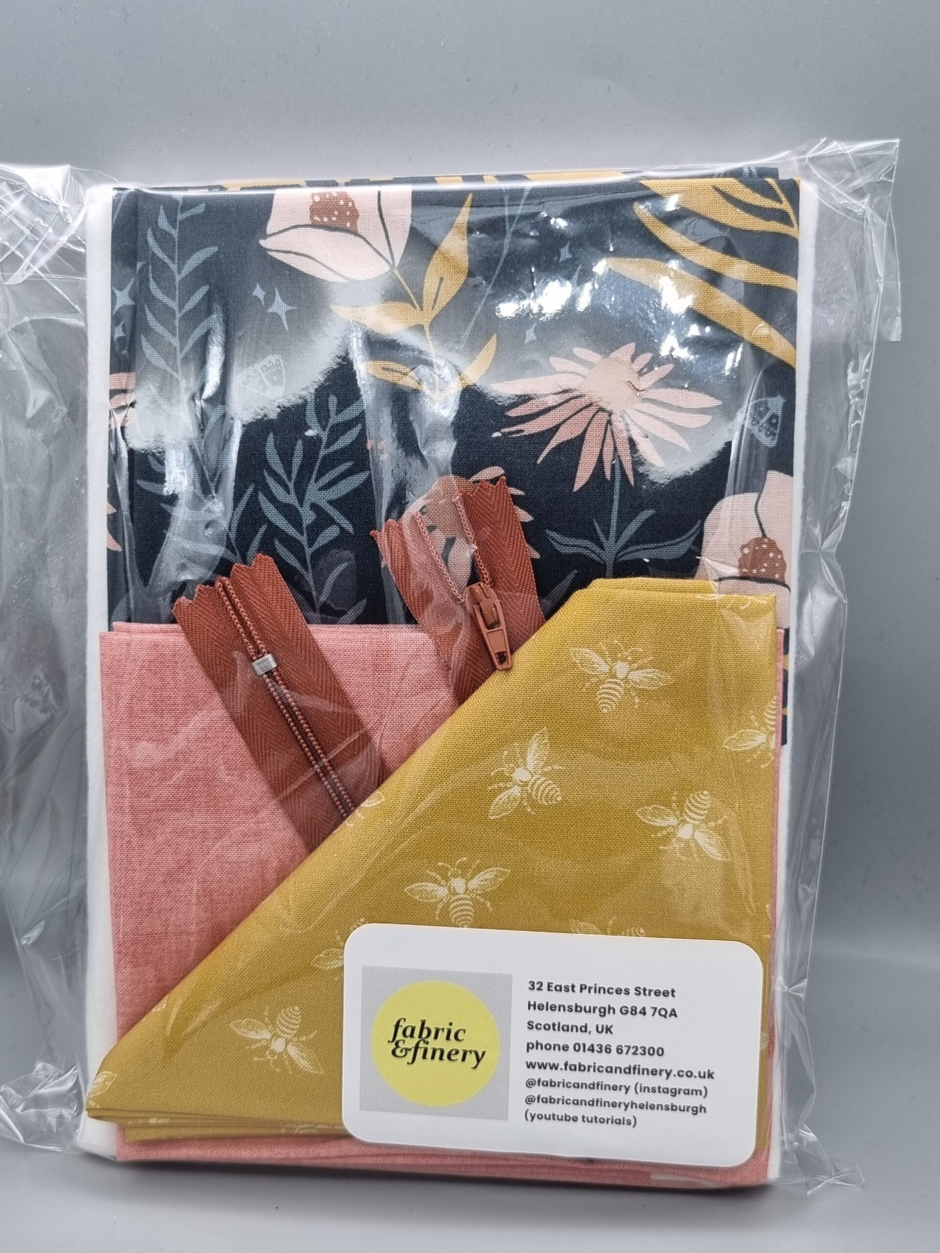 Vibrant fabric and zipper pack featuring floral and bee prints, ideal for sewing, crafting, and DIY textile projects, showcasing high-quality fabric and accessories from Fabric & Finery UK.