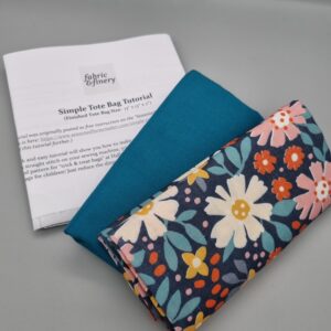 Vibrant floral fabric swatches including plain teal and patterned navy blue with colourful flowers for crafting, sewing, and dressmaking projects. Perfect for custom clothing and accessories.