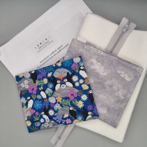 Vibrant fabric swatch featuring puffins and seabirds for quilting and sewing projects, alongside sewing notions like zippers, interfacing, and padding, ideal for fabric and finery enthusiasts.