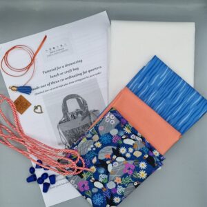 Brightly coloured fabric swatches and sewing accessories for craft projects and dressmaking, including patterned and plain fabrics, cords, and tailor’s tools from Fabric & Finery UK.