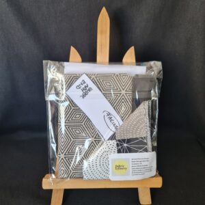 Vibrant fabric bundle with geometric and abstract patterns, perfect for sewing and craft projects, packaged in a clear bag with branding from Fabric & Finery.