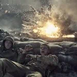 "Two soldiers in combat uniforms take cover behind sandbags as an explosion erupts nearby on a smoky, chaotic battlefield, with flames and debris filling the air."