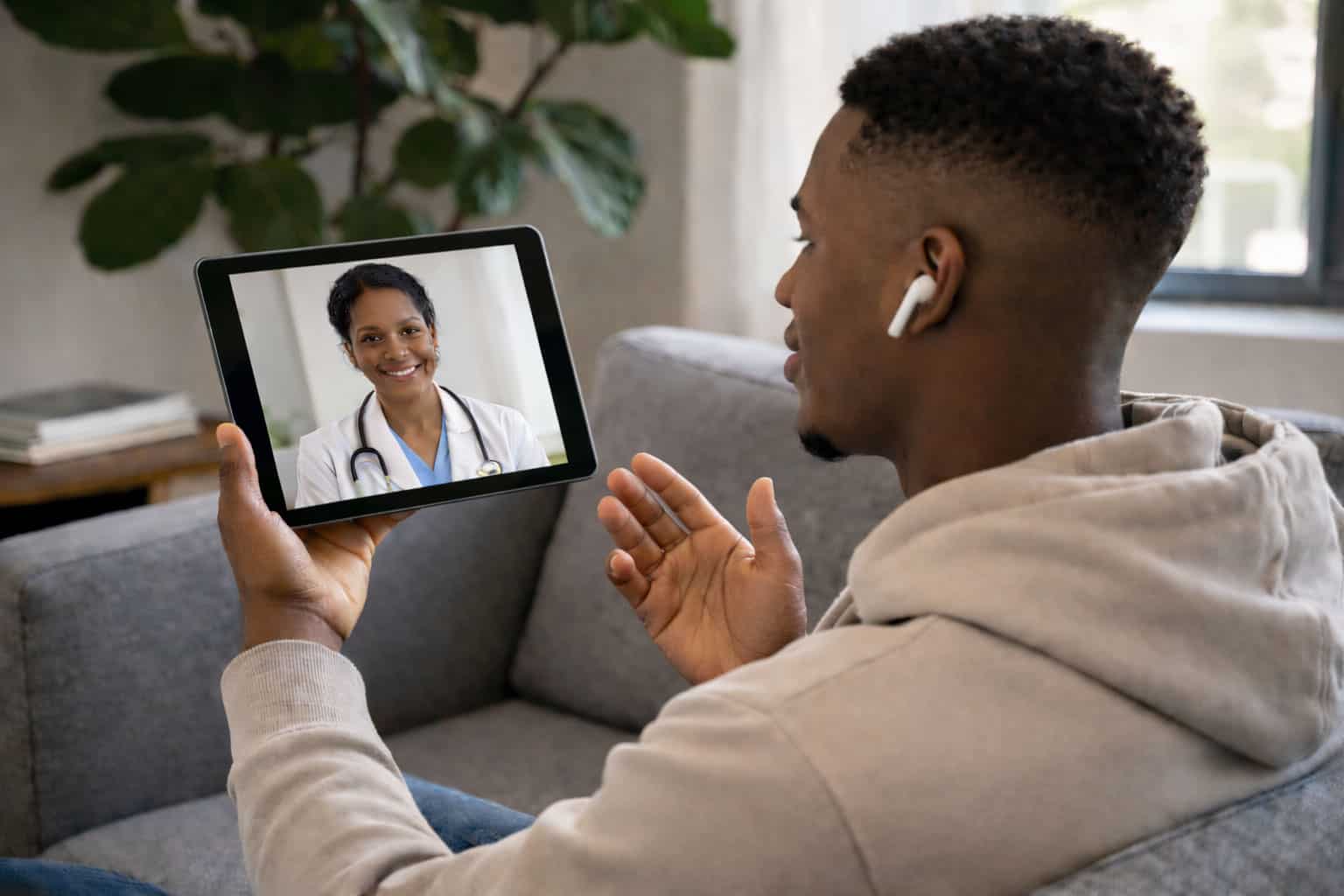 Young professional using telemedicine app on a tablet at home