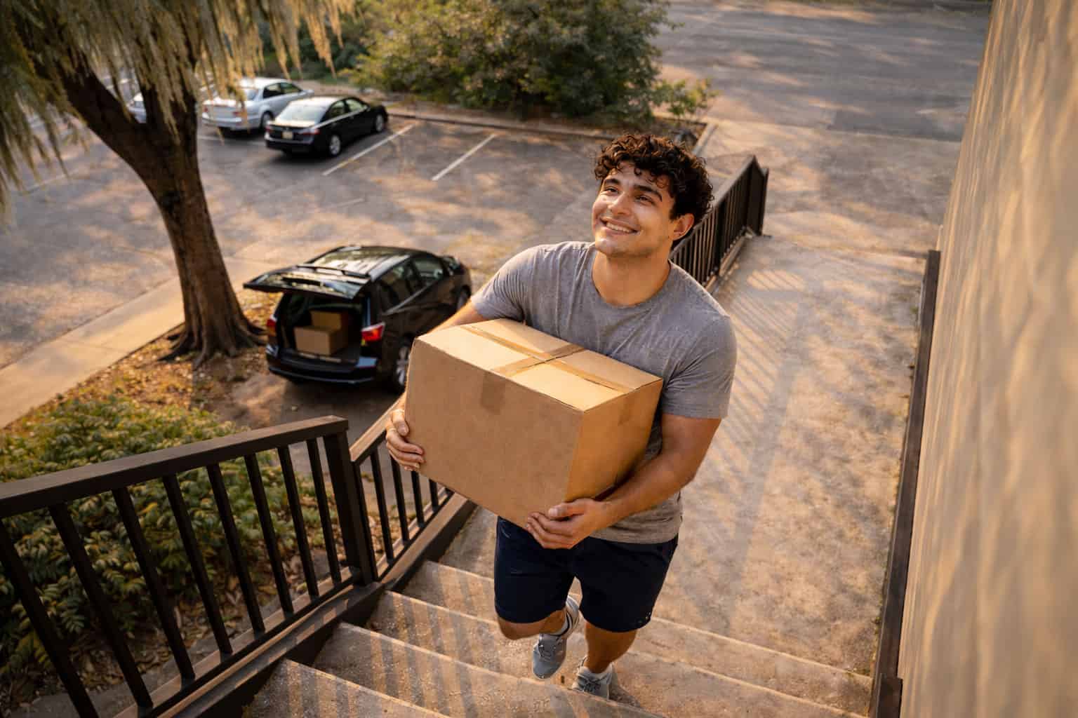 Recent college graduate moving boxes into first apartment in Alabama