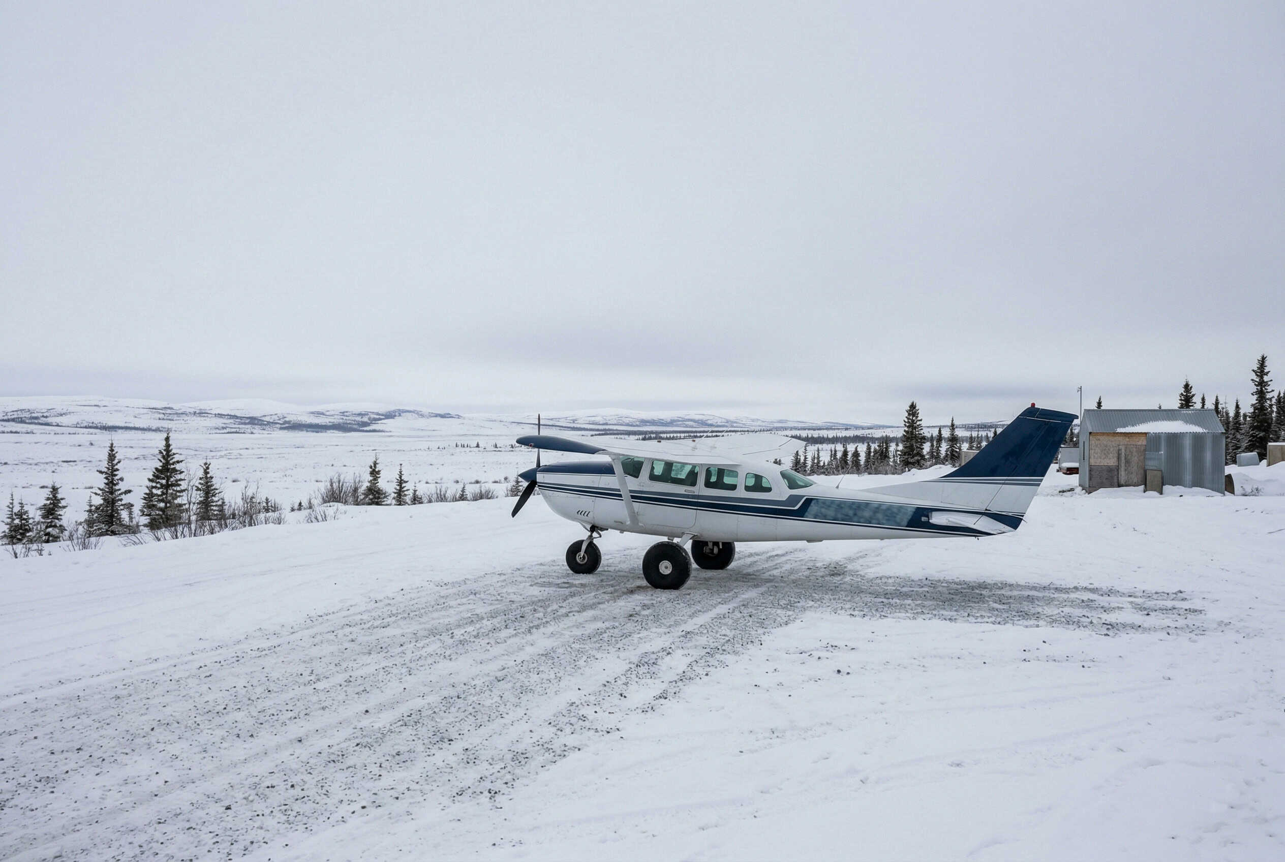 Small bush plane on a snow-covered airstrip in rural Alaska — medical transport access for remote communities