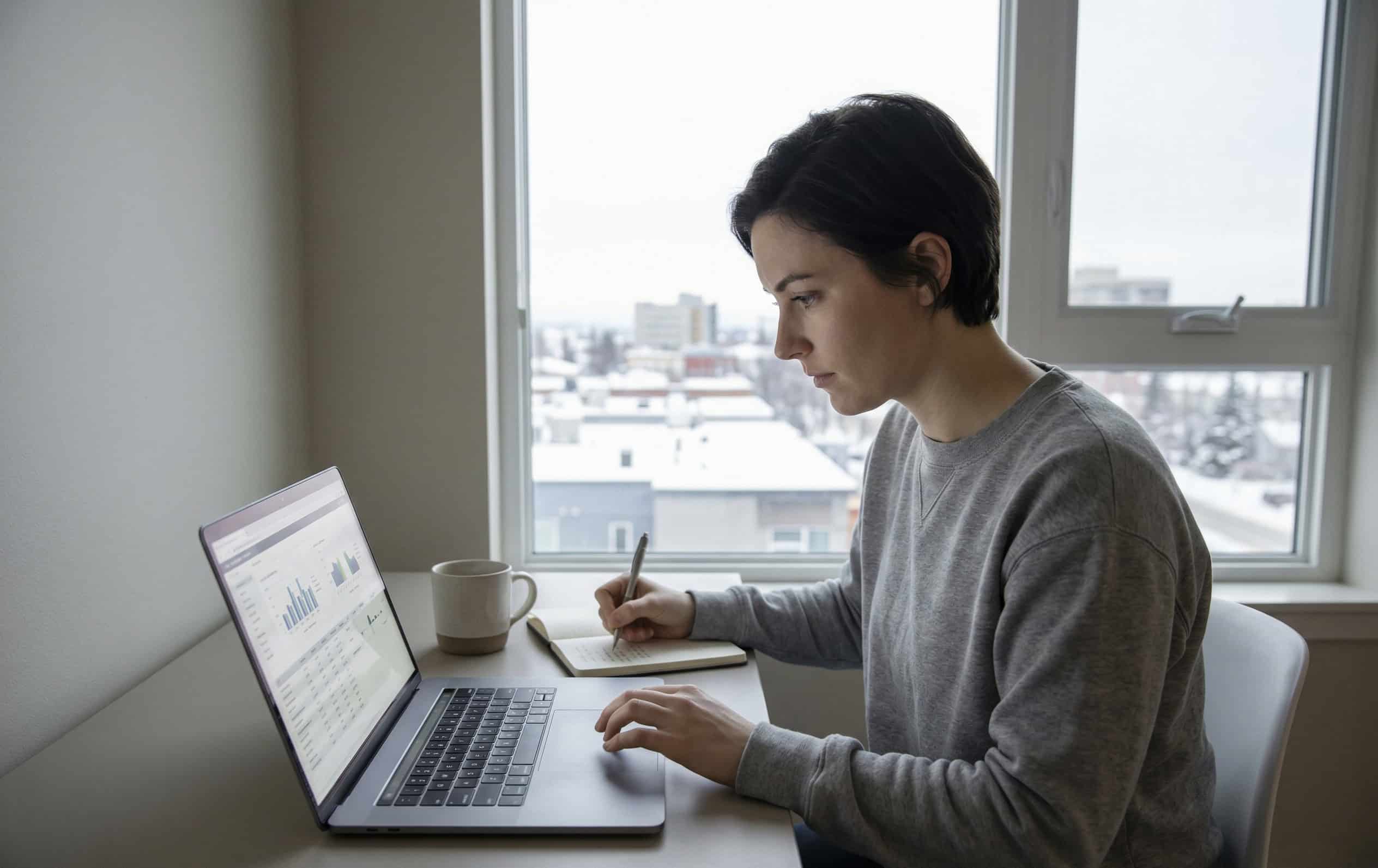 Alaska resident comparing cheap health insurance plan options on a laptop at a desk in Anchorage