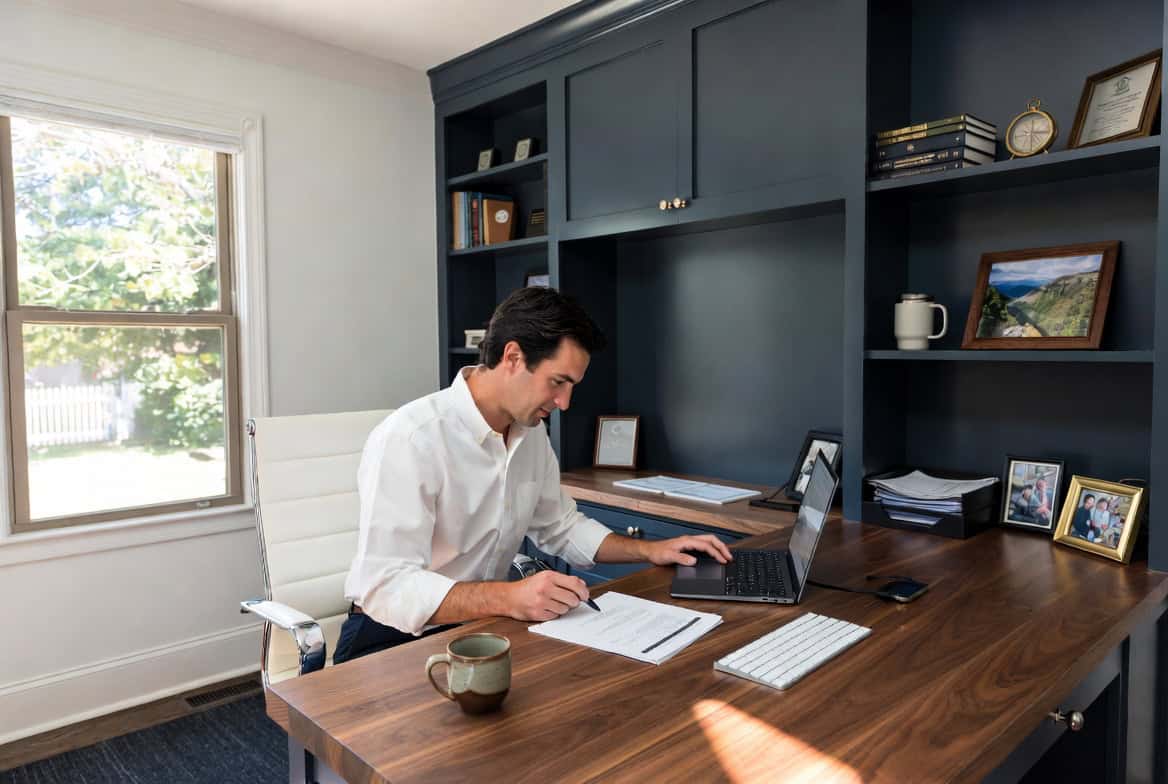 Self-employed Connecticut man reviewing private health insurance options at a Stamford home office desk in 2026