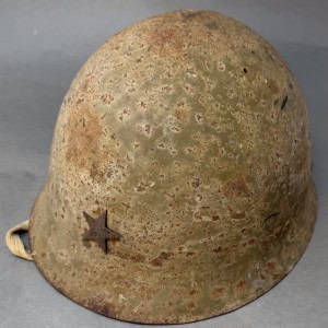 WWII military helmet with a star insignia, showing signs of rust and wear, displayed on a neutral ba.