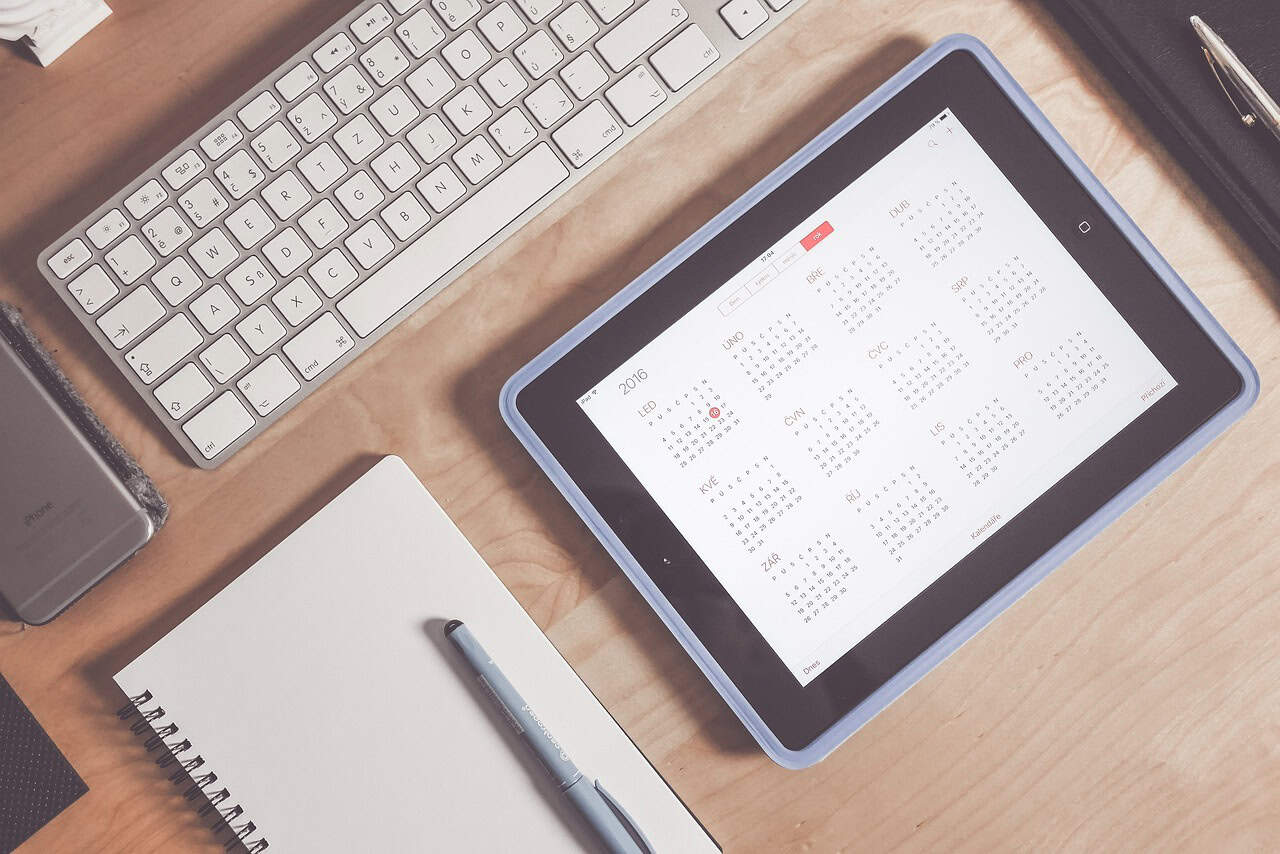 Calendar app on tablet with keyboard for digital marketing planning and social media schedule management.