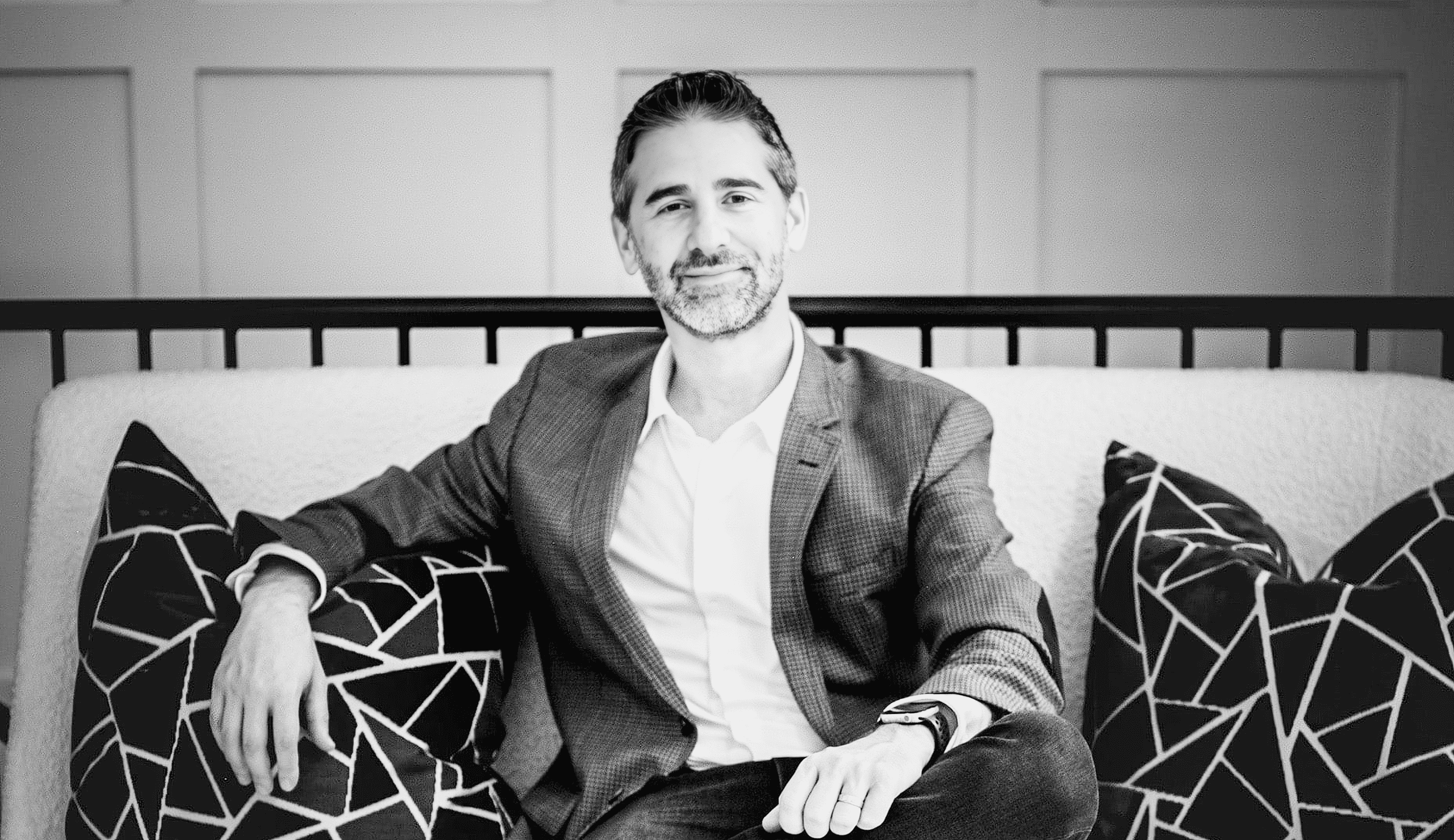 Dr. Marcus Goodman, founder of Goodman Dermatology, sits on a couch