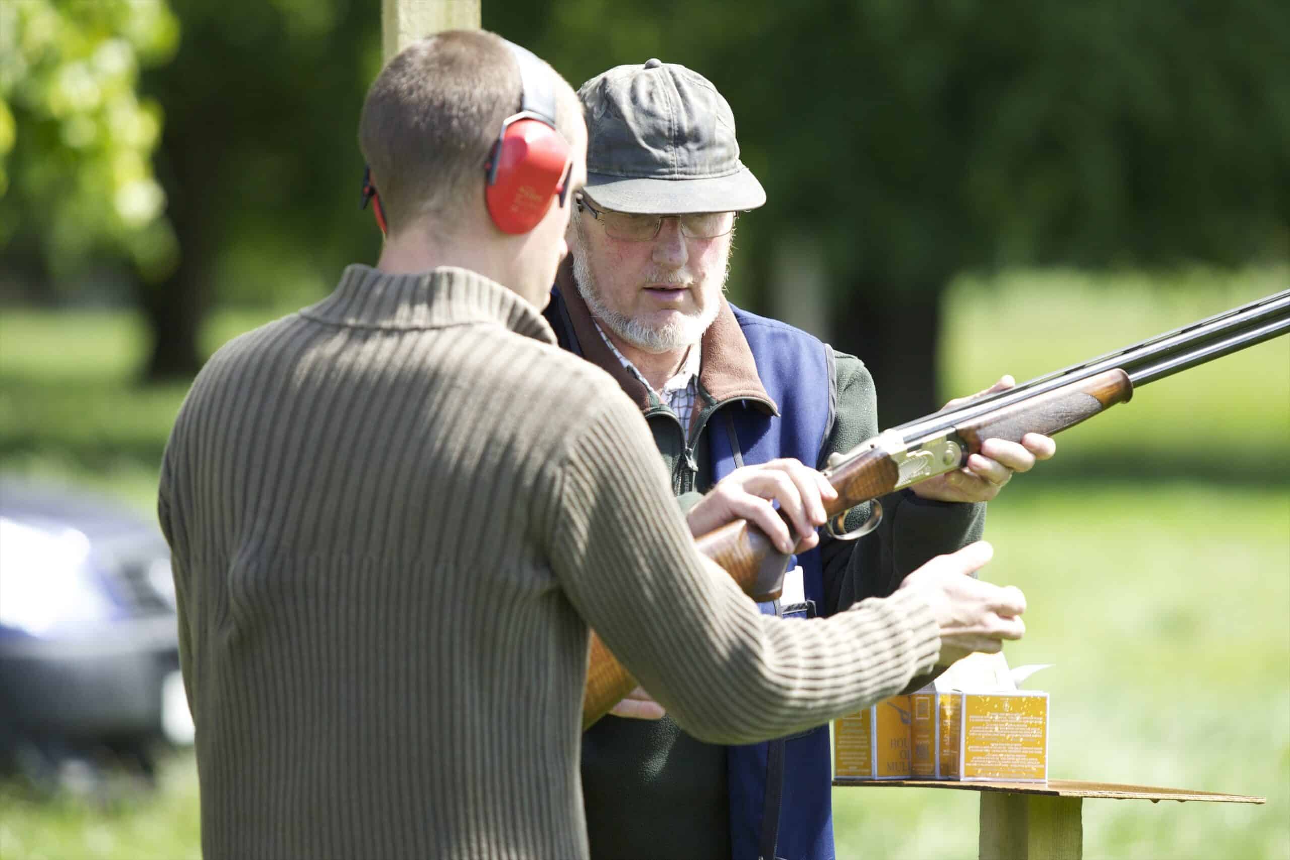Instructor provides clay shooting guidance at Gordon Castle estate in Moray, Scotland, during a country sporting experience.