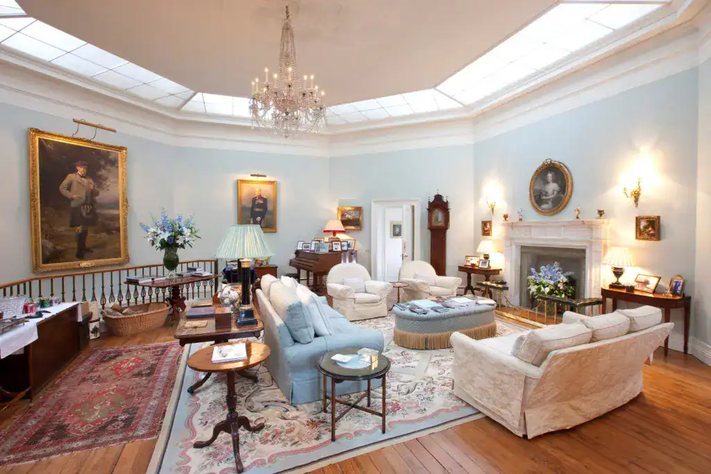 Elegant octagonal hall at Gordon Castle with chandelier and portraits