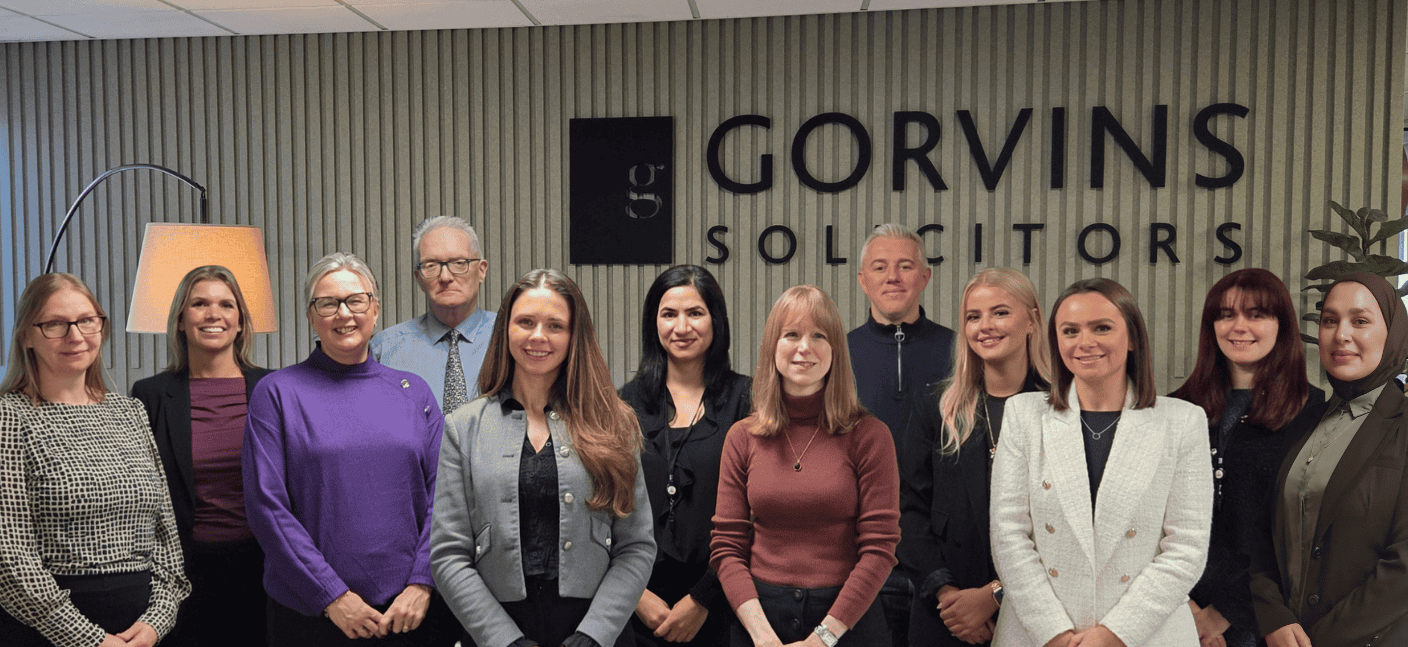 Business professionals group photo outside Gorvins Solicitors office, corporate team ready for legal services.