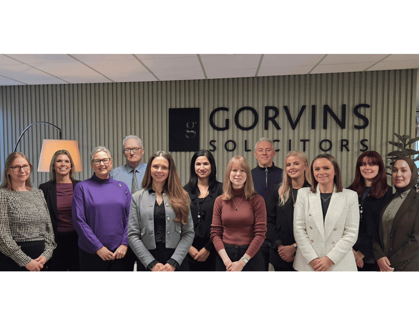 Group of diverse legal professionals standing together in an office environment at Gorvins Solicitors.