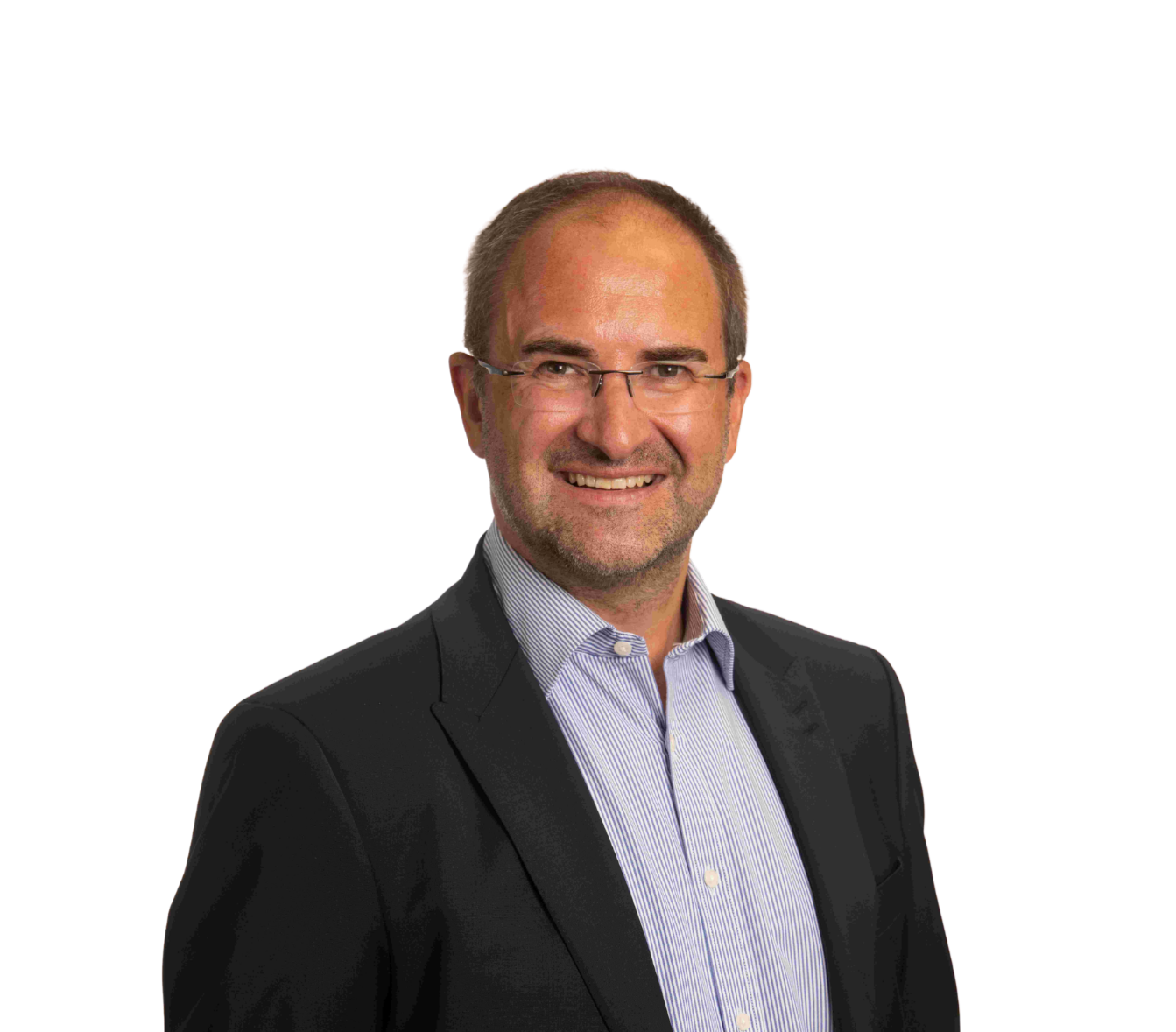 Businessman smiling confidently in a suit and glasses, standing against a plain background.