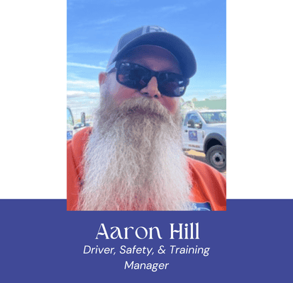 Aaron Hill, VannGo driver, safety, and training manager, outdoors with vehicles.
