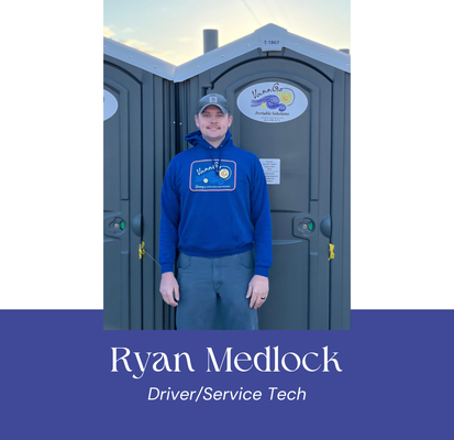 Ryan Medlock, VannGo driver and service technician, standing in front of portable toilet.