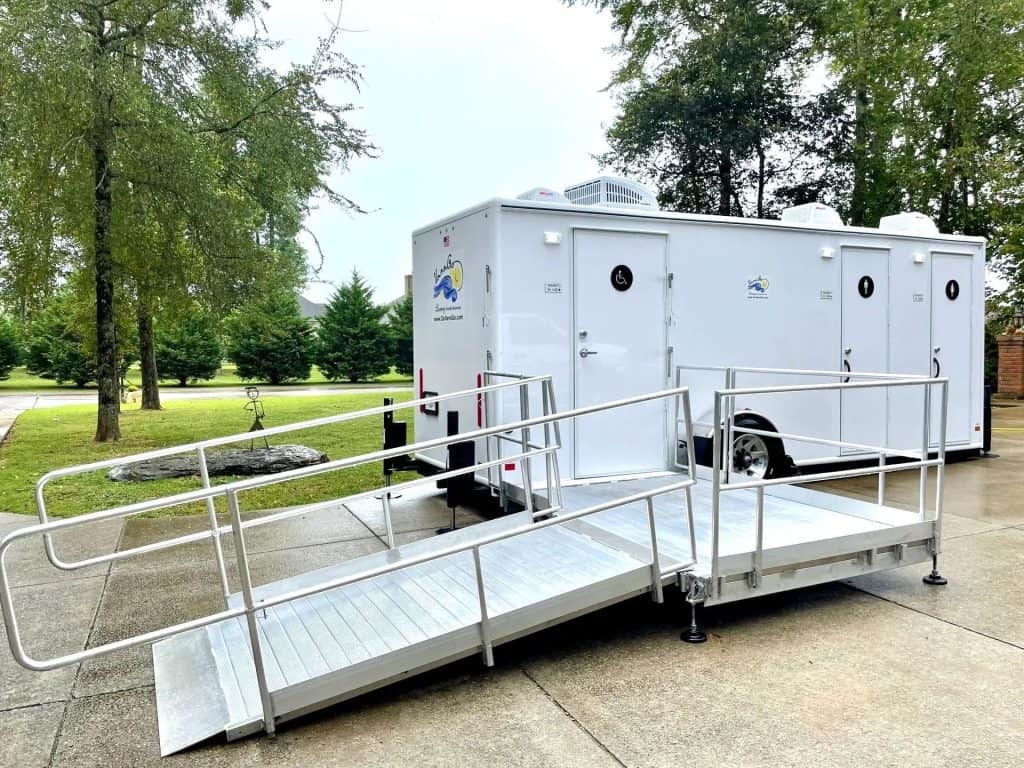 Portable restroom trailer with wheelchair accessible ramp for events.