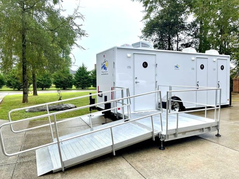Portable restroom trailer with wheelchair accessible ramp for events.