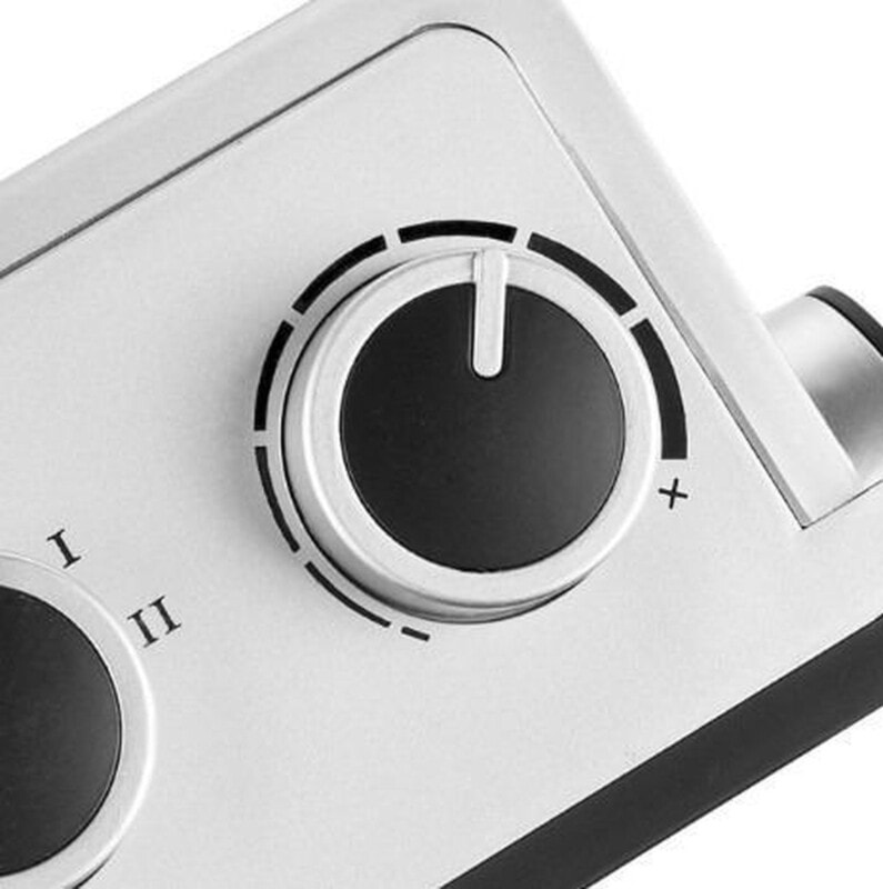 Regelknoppen van een elektrische grill. De afbeelding toont een zilveren bedieningspaneel met twee zwarte draaiknoppen, voorzien van duidelijke markeringen voor instellingen. De linkerknop heeft twee standen (I en II), terwijl de rechterknop een uitgebreide schaal heeft van laag naar hoog met een extra stand aangegeven met een kruisje. Dit product is ontworpen voor gebruiksgemak en nauwkeurige temperatuurregeling.