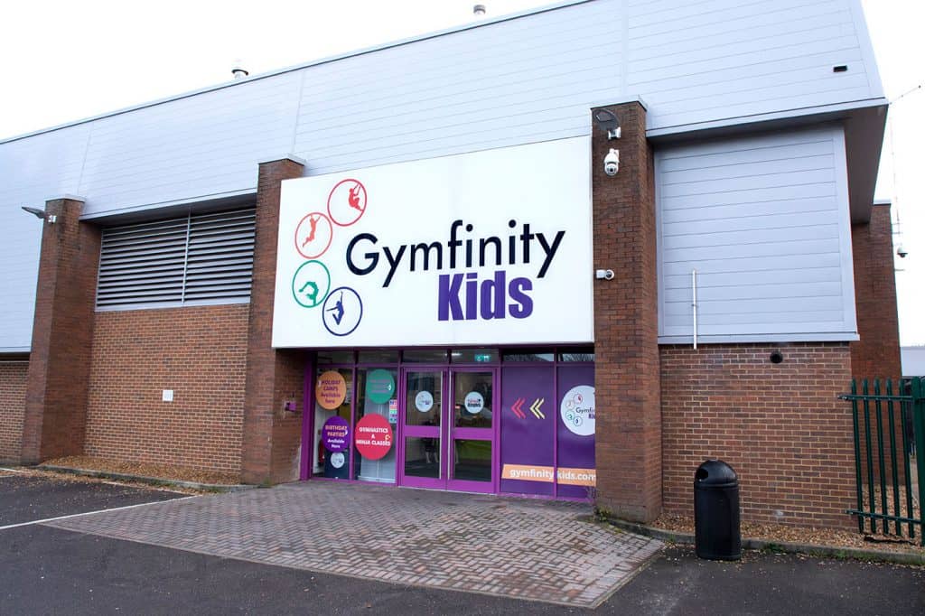 Bright modern gymnastic centre for children with colourful signage and large windows, offering gymnastics classes, birthday parties, and holiday camps for kids.