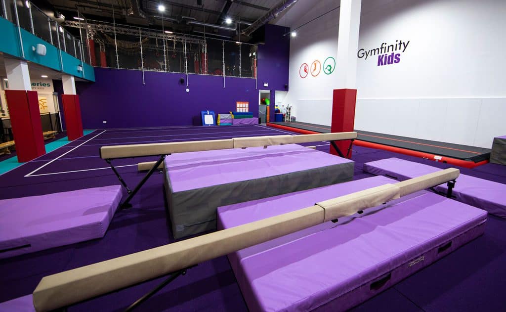 Flexible gymnastics mats and uneven bars for kids' training at Gymfinity Kids indoor sports facility.