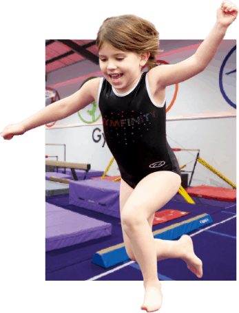 Bright young girl in gymnastic outfit performing a leap on gymnastics mats at an indoor training facility.
