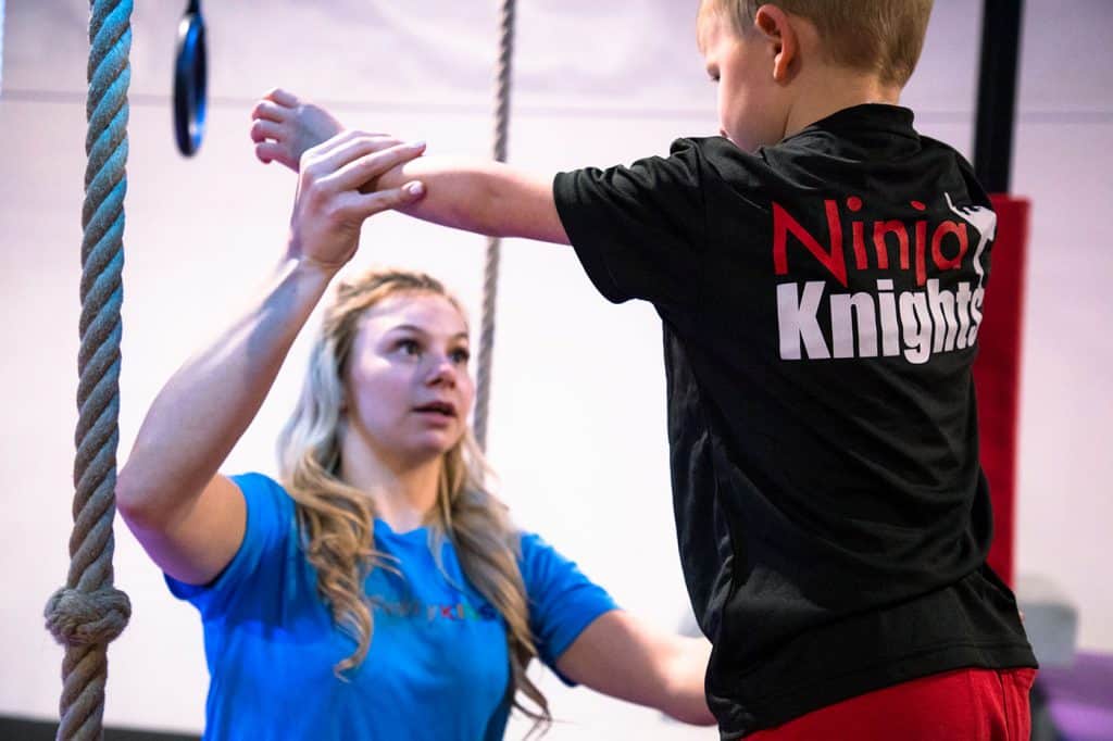 Bench press for kids, training in martial arts gym, kids ninja training, children practicing strength exercises, Ninja Knights branded sportswear for children.