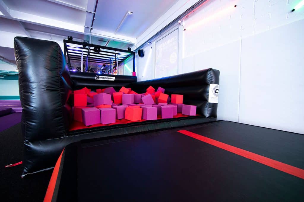 Soft play area with colourful foam blocks and a trampoline for children’s entertainment in an indoor recreational space.