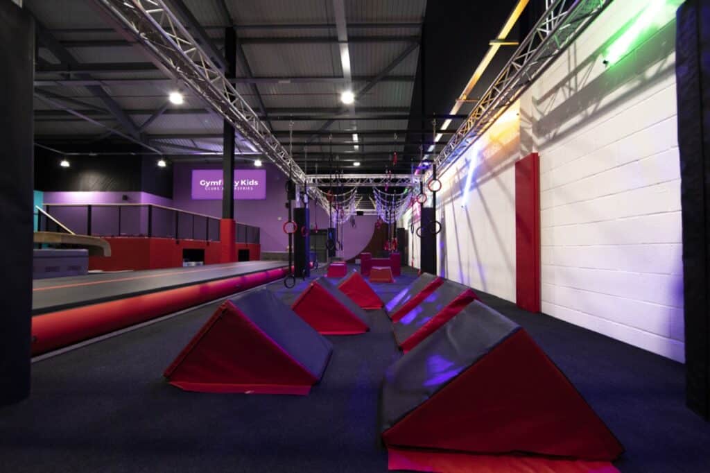 Climbing gym indoor obstacle course with foam blocks, rings, and hanging ropes for children’s activities and physical development. Suitable for kid-friendly fitness and adventure play.