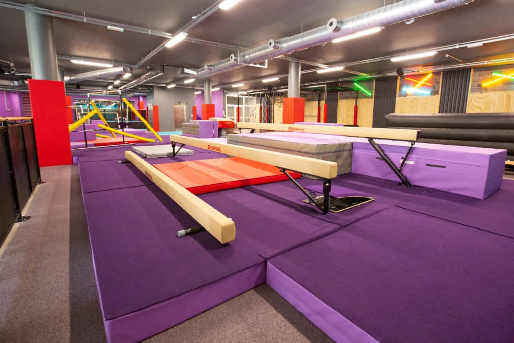 Paddington Jump Studio gymnastics training facility with purple mats, balance beams, foam pits, and colourful gym equipment for professional tumbling and acro practice.