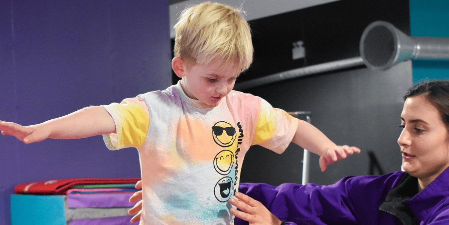 - A young boy with Down syndrome balancing during a physical therapy session at a rehabilitation centre in the UK.