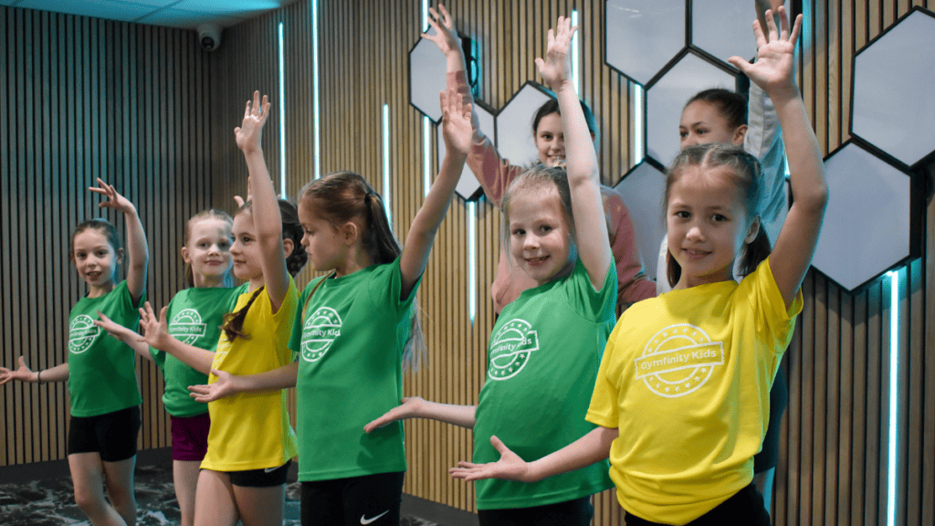 Energetic children in colourful sportswear participating in a dance or exercise class at the gym.