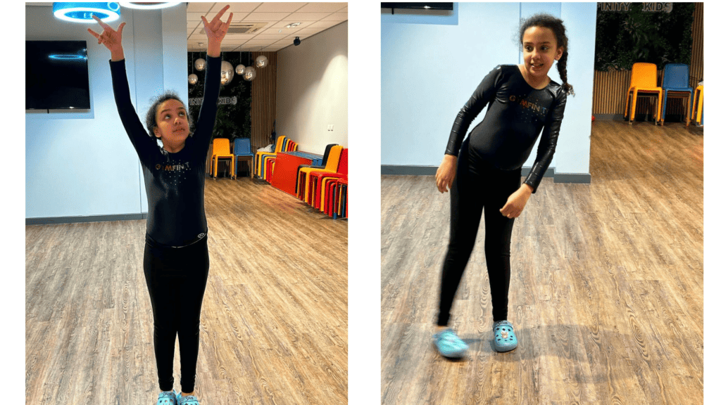 Brightly smiling young girl holding a "Star of the Week" certificate with an adult woman at a gymnastics centre, celebrating achievement and success.